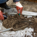 戴着手套的人，将土壤样本放在防水布上