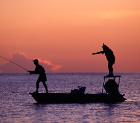 钓鱼在日落的两个朋友